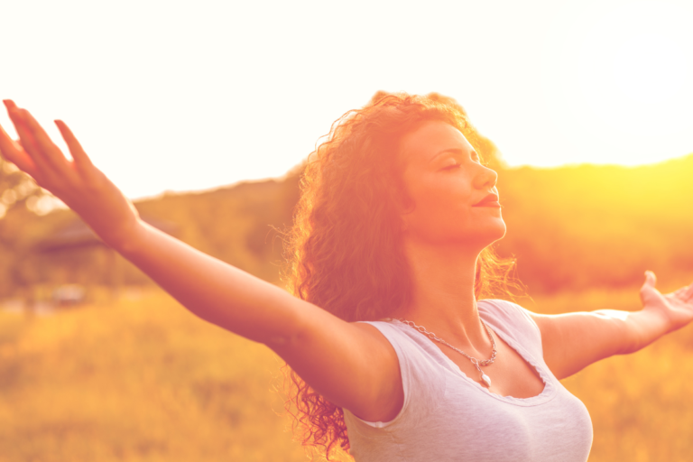 A Woman Smiling In The Sun After Using A Vape Cartridge - Entour Botanical Specialists